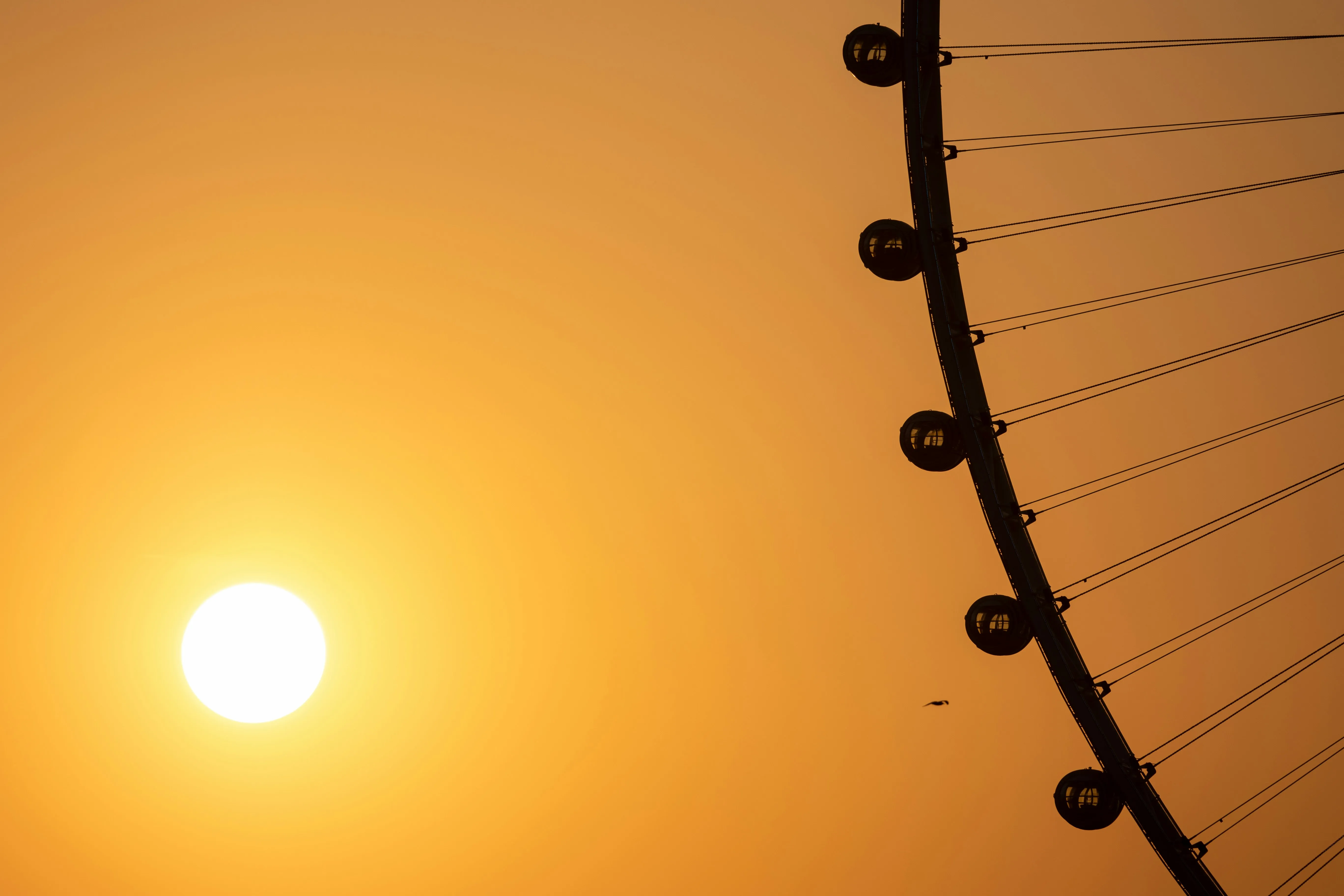 Riesenrad mit Sonne im Hintergrund